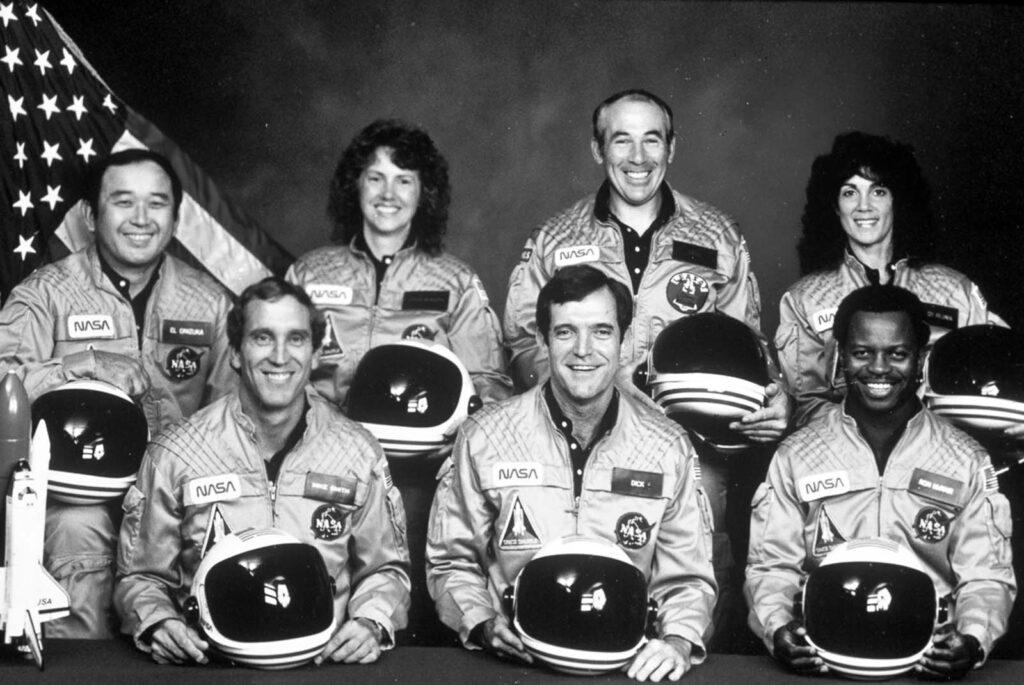 A tripulação do Challenger, da esquerda para a direita: o especialista da missão Ellison Onizuka, o piloto Michael Smith, Christa McAuliffe, o comandante Francis “Dick” Scobee, o especialista em carga útil Gregory Jarvis, a especialista da missão Judith Resnik e o especialista da missão Ronald McNair.