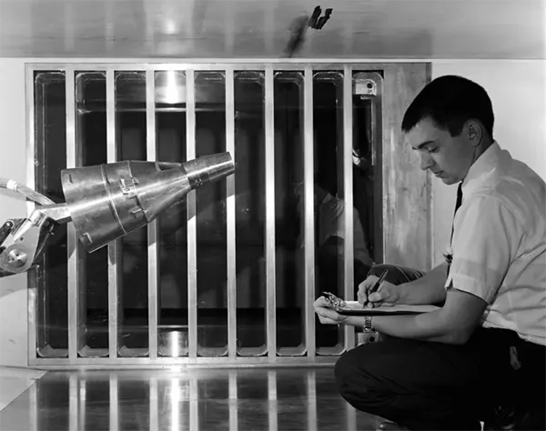 Em 1962, uma cápsula Gemini é testada no Túnel de Vento do Plano Unitário, no Centro de Pesquisa Ames da NASA, na Califórnia. Ao contrário das cápsulas Mercury, que transportavam um astronauta, as cápsulas Gemini transportavam dois astronautas e foram projetadas para testar capacidades críticas, como caminhadas espaciais e atividades extraveiculares, em missões futuras.