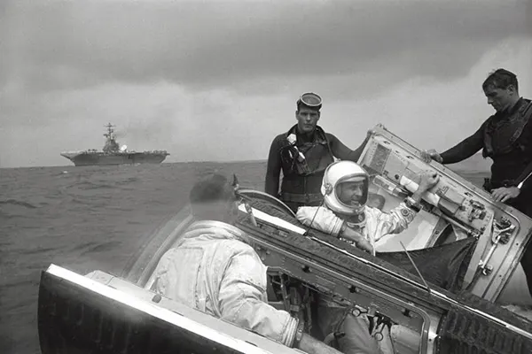 Os astronautas Thomas P. Stafford e Eugene A. Cernan sentam-se em sua nave espacial Gemini com as escotilhas abertas enquanto aguardam a chegada da nave de recuperação USS Wasp. 6 de junho de 1966.