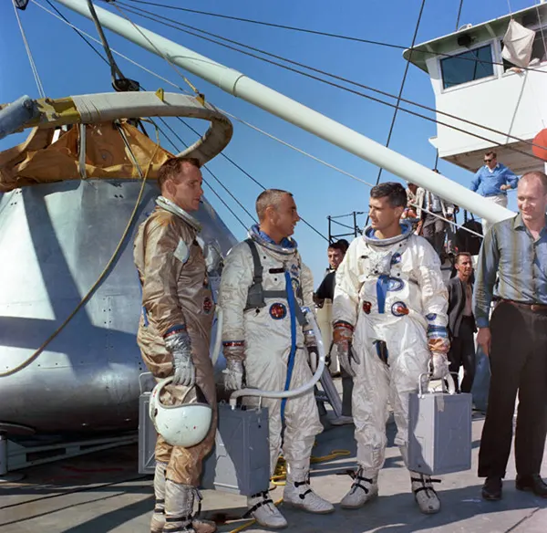 A tripulação da Apollo 1 se prepara para o treinamento de saída de água no Golfo da América. Da esquerda para a direita: os astronautas Edward H. White II, Virgil I. Grissom e Roger B. Chaffee. 27 de outubro de 1966.