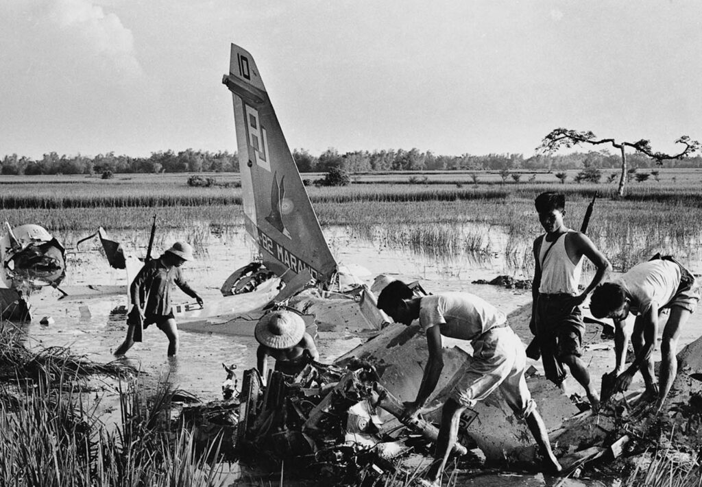 Milicianos vasculham os destroços de um avião da Marinha dos EUA abatido nos arredores de Hanói. A aeronave TLV A-7C Corsair pilotada pelo Tenente Stephen Owen Musselman foi abatida perto de Hanói em 10 de setembro de 1972. O Tenente Musselman ejetou-se da aeronave antes da queda. Ele permaneceu desaparecido até 1º de março de 1978, quando o Secretário da Marinha aprovou uma conclusão presumida de morte. Em 7 de julho de 1981, os restos mortais, que foram confirmados como sendo seus, foram devolvidos aos Estados Unidos pelo governo do Vietnã. (Foto de Doan Cong Tinh).