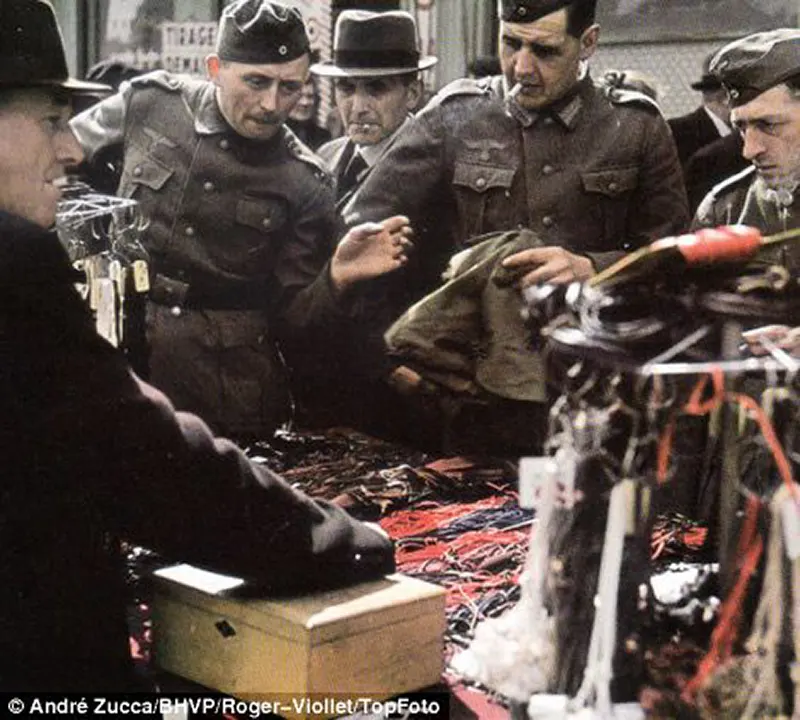 Soldados nazistas são mostrados participando da vida em Paris e fazendo compras no mercado.