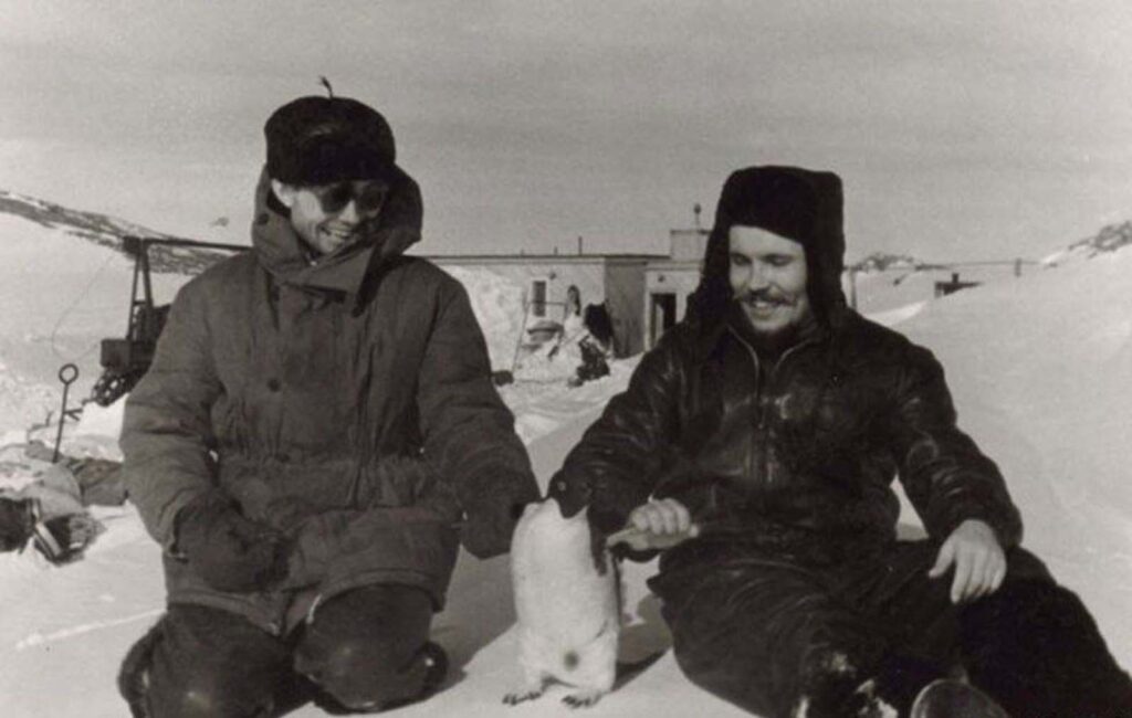 Leonid Rogozov (à direita) relaxando com um dos habitantes mais conhecidos da Antártida.