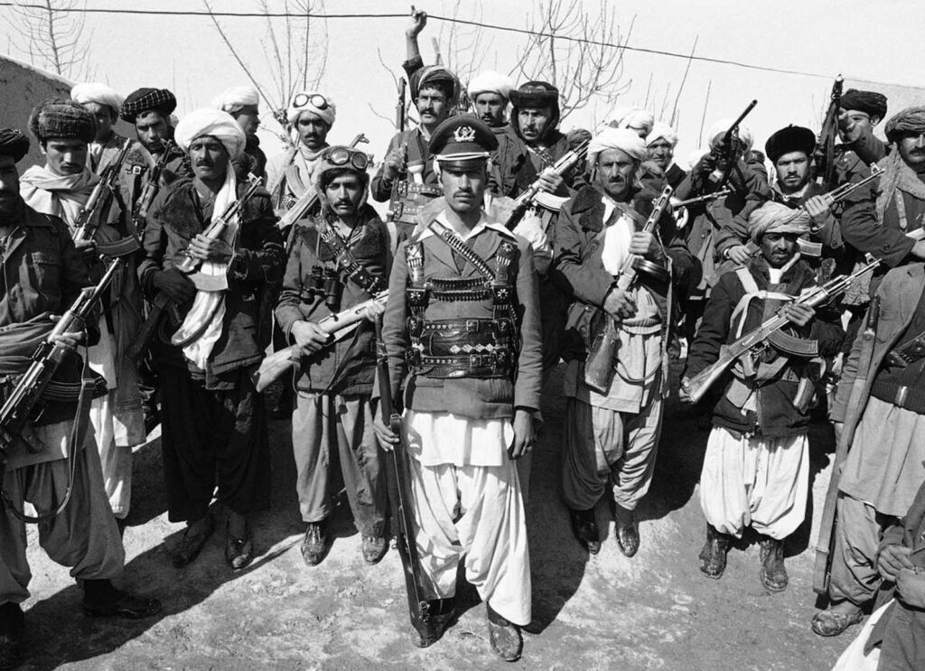 Um mujahideen, capitão do exército afegão antes de desertar, posa com um grupo de rebeldes perto de Herat, Afeganistão, em 28 de fevereiro de 1980. Na época, foi relatado que a capital afegã, Cabul, voltou ao normal pela primeira vez desde que sangrentos tumultos antissoviéticos eclodiram lá, matando mais de 300 civis e um número desconhecido de soldados soviéticos e afegãos.