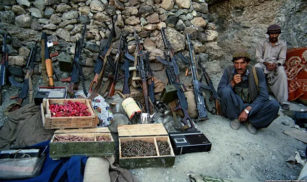 Membros dos "mujahedin" antissoviéticos, como ficaram conhecidos os combatentes jihadistas que se opunham aos soviéticos, com pilhas de armas. Alegadamente, a partir de 1979, a CIA começou a financiar secretamente os grupos militantes muçulmanos que passariam a década seguinte lutando contra os soviéticos.