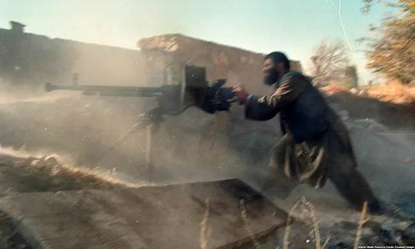 Um combatente com uma metralhadora pesada. Alguns dos grupos mujahedin financiados pela CIA eram islâmicos radicais que mais tarde formariam grupos designados como "organizações terroristas". Embora Osama bin Laden tenha lutado contra os soviéticos, é controverso se ele alguma vez recebeu ajuda dos EUA.